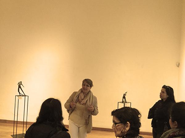 Tatiana Martin mostrando sus obras a un grupo de mujeres